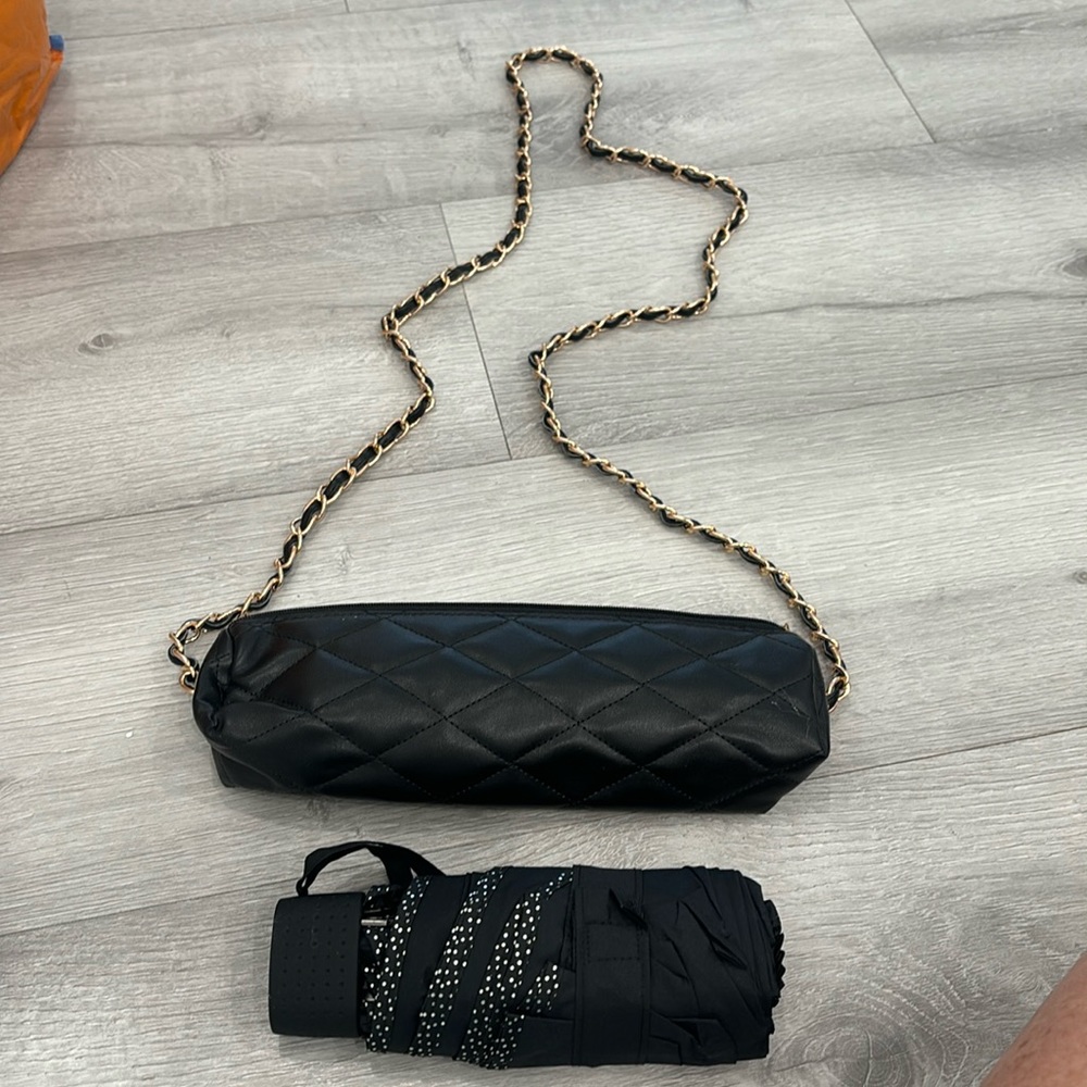 Black quilted umbrella case with small black umbrella inside no name case